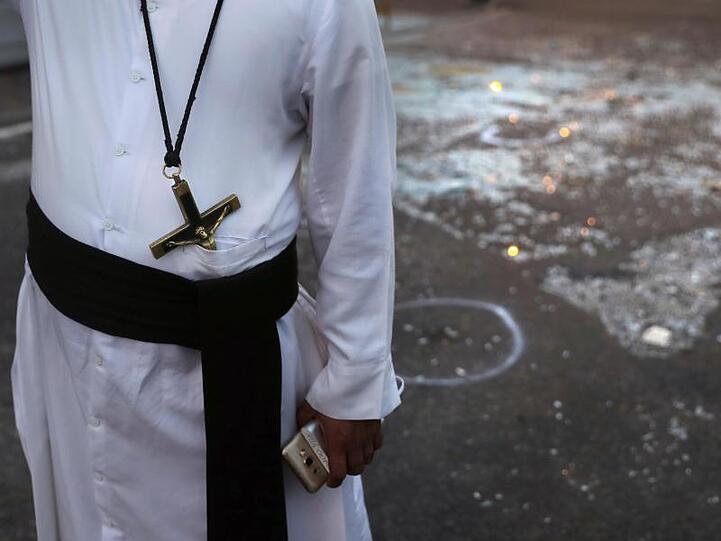 Nach den Anschlägen: Ein katholischer Priester steht neben Glasscherben in Colombo.
