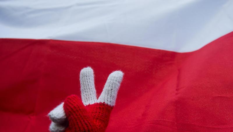 Peace-Zeichen vor polnischer Nationalflagge während eines Protests gegen die Justizreform. Polens Regierung hat die umstrittene Zwangspensionierungen oberster Richter zunächst wieder aufgehoben. Peace-Zeichen vor polnischer Nationalflagge während eines Protests gegen die Justizreform. Polens Regierung hat die umstrittene Zwangspensionierungen oberster Richter zunächst wieder aufgehoben.