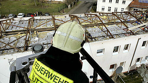 Komplett abgedeckt: ein Feuerwehrmannblickt auf das Dach eines Wohnhauses in Hessen Komplett abgedeckt: ein Feuerwehrmannblickt auf das Dach eines Wohnhauses in Hessen