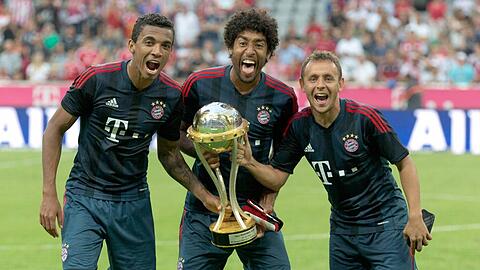 Luiz Gustavo und Dante (hier mit Rafinha und dem Uli-Hoeneß-Cup) reisen am 14. August in die Schweiz. Beim Testspiel der brasilianischen Nationalmannschaft gegen die Schweiz stehen sie auf dem Platz.