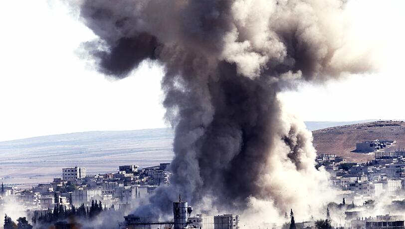 Kampf gegen die IS-Miliz in Kobane: Nach einem Luftangriff steigt eine riesige Rauchwolke über der syrischen Stadt auf. Kampf gegen die IS-Miliz in Kobane: Nach einem Luftangriff steigt eine riesige Rauchwolke über der syrischen Stadt auf.