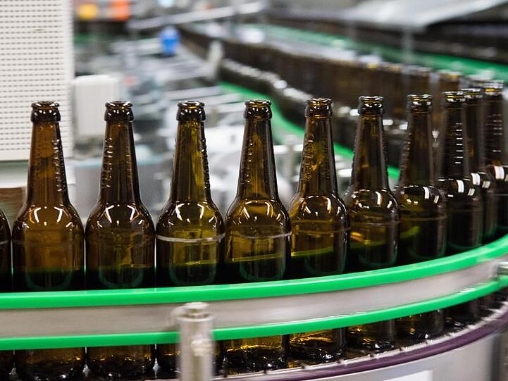 Gewaschene Bierflaschen laufen durch die Produktion einer Brauerei.