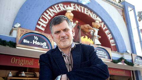Ungewöhnliche Protestform: Künstler Tommy Schmidt vor der Hendlbraterei. Ab Sonntag lässt er ein Huhn für die Zeit des Oktoberfests in einer Pension neben der Wiesn logieren. Mehr als eine halbe Million Brathendl wurden 2010 auf der Wiesn verzehrt.
