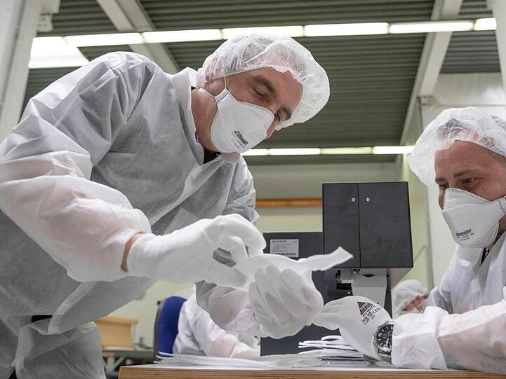 Mitarbeiter der Zender Germany GmbH fertigen Schutzmasken an.