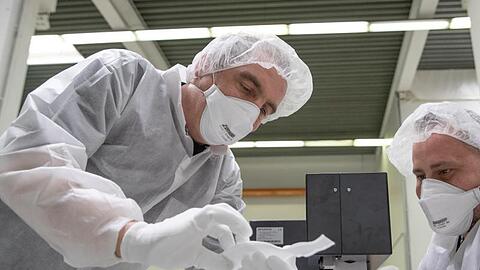 Mitarbeiter der Zender Germany GmbH fertigen Schutzmasken an.