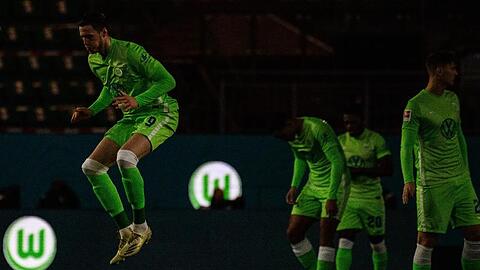 Das Logo vom VfL Wolfsburg leuchtet vor Spielbeginn auf Werbebanden, während die Spieler das Spielfeld betreten.