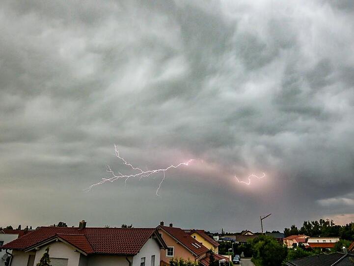 Blitze zucken während eines Gewitters am Abendhimmel über Straubing.