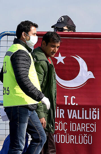 Rund 200 Flüchtlinge werden im Hafen von Izmir von der türkischen Polizei zur Registrierungsstelle begleitet.