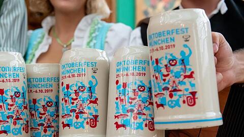 Bei der Vorstellung des offiziellen Wiesn-Maßkrugs 2019 stoßen Gäste mit dem neuen Maßkrug an. Foto: Sven Hoppe/Archiv