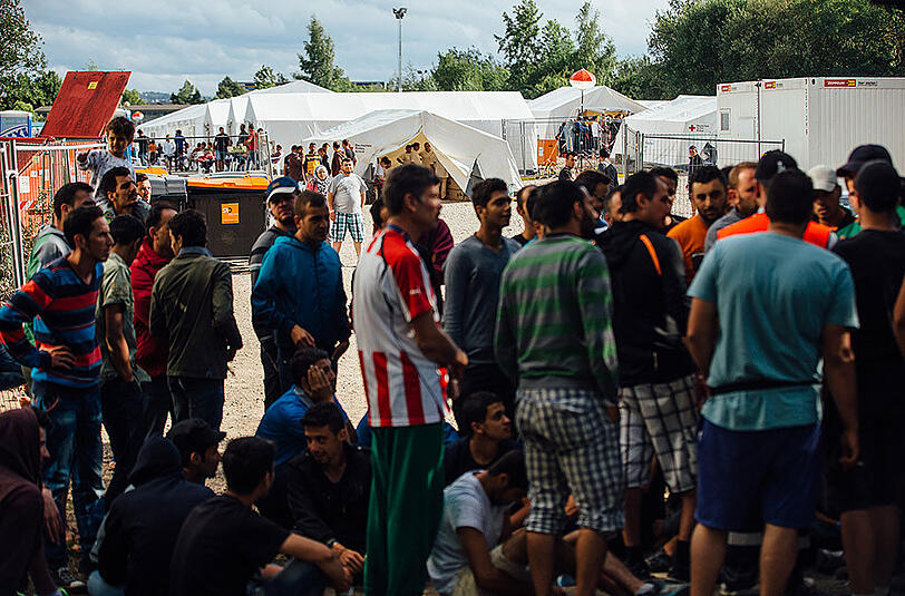 Flüchtlinge versammeln sich am Eingang des Aufnahmelagers an der Bremer Straße in Dresden.