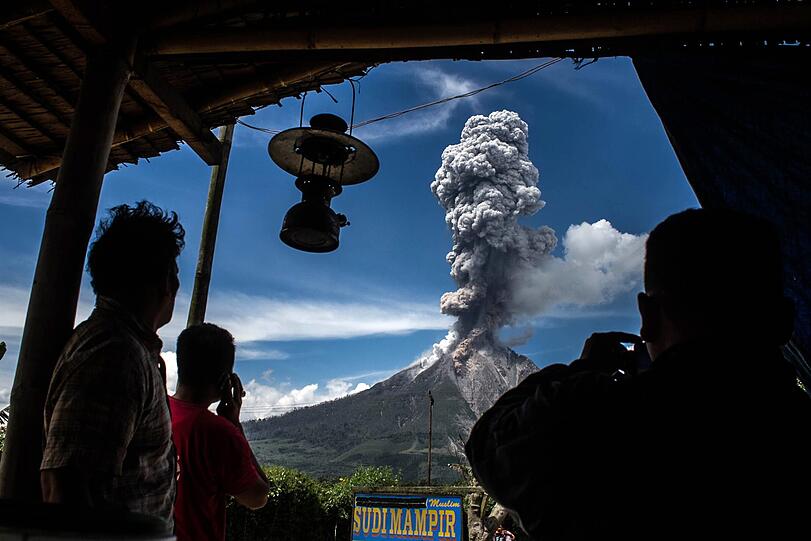 04.02.2017: Ein Einwohner von Karo (Nord-Sumatra/Indonesien) beobachtet den Ausbruch des Sinabung-Vulkans. Gegen Ende des Jahres versetzt auch der Vulkan Agung auf Bali die Menschen in Angst vor einem Ausbruch. Flüge fallen aus, Tausende Touristen sitzen auf der Urlaubsinsel fest.