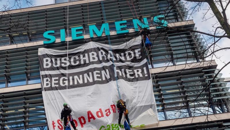 Aktivisten von Greenpeace hängen an der Fassade der Siemens-Zentrale ein Transparent. Foto: Peter Kneffel/dpa Aktivisten von Greenpeace hängen an der Fassade der Siemens-Zentrale ein Transparent. Foto: Peter Kneffel/dpa