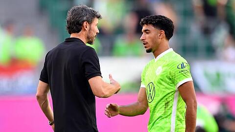 Wolfsburgs Trainer Mark van Bommel klatscht nach der Pokalpartie gegen Preußen Münster mit Omar Marmoush ab.