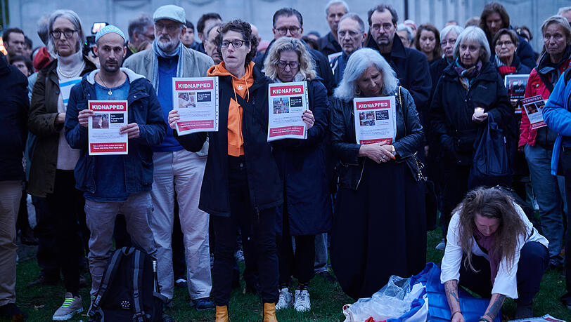Menschen halten Blätter mit Vermissten-Anzeigen von Personen, die in Israel dem Hamas-Überfall zum Opfer fielen. Bei der Veranstaltung "Gedenken der Opfer des Terrors der Hamas. Solidarität mit den Menschen in Israel und Palästina" auf dem Wittenbergplatz in Berlin wurden Namen vermisster Personen vorgelesen.