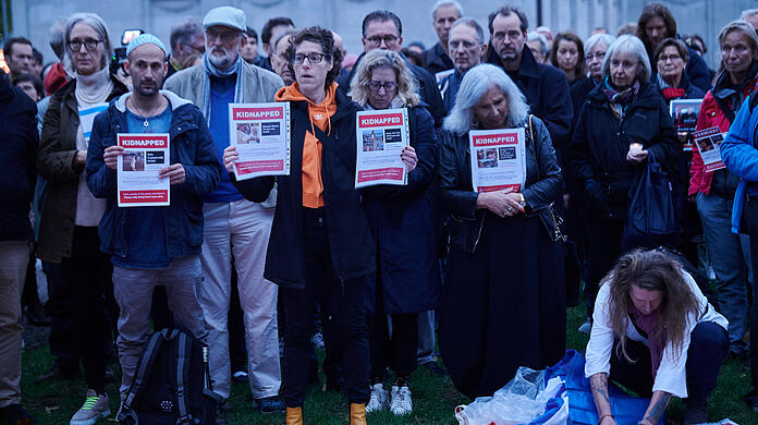 Menschen halten Blätter mit Vermissten-Anzeigen von Personen, die in Israel dem Hamas-Überfall zum Opfer fielen. Bei der Veranstaltung "Gedenken der Opfer des Terrors der Hamas. Solidarität mit den Menschen in Israel und Palästina" auf dem Wittenbergplatz in Berlin wurden Namen vermisster Personen vorgelesen.