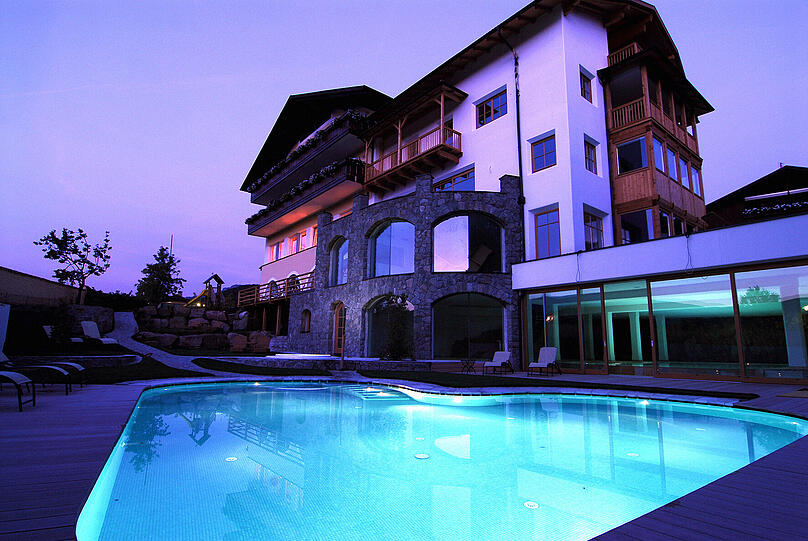 Außenansicht des Hotels Völser Hof mit Poollandschaft.