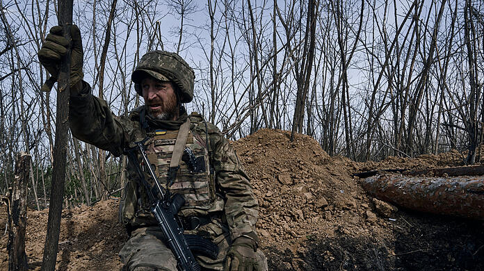 Ein ukrainischer Soldat schaut aus einem Schützengraben an der Frontlinie in Bachmut.