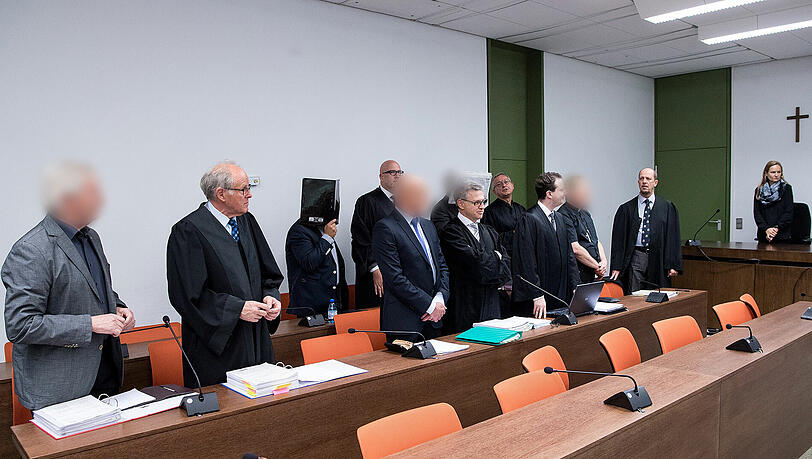 Millionenbetrug: Die fünf Angeklagten stehen vor Prozessbeginn mit ihren Anwälten im Verhandlungssaal des Landgerichts. Millionenbetrug: Die fünf Angeklagten stehen vor Prozessbeginn mit ihren Anwälten im Verhandlungssaal des Landgerichts.