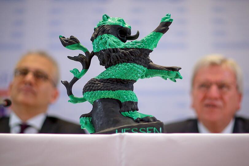Der hessische Löwe schwarz-grün: seit 2 Jahren regiert in Hessen die CDU mit den Grünen. Bei einer Zwischenbilanz-Pressekonferenz steht das Wahrzeichen des Landes zwischen den beiden Vorsitzenden der Parteien.