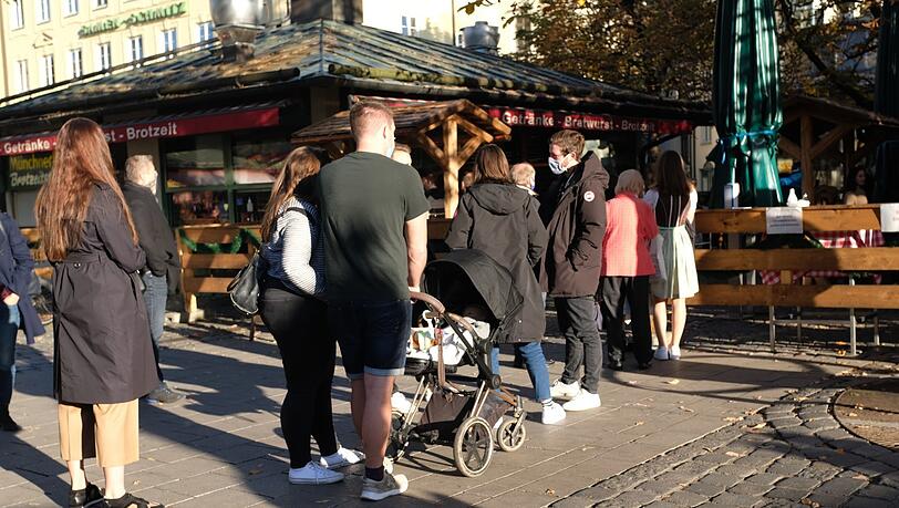 Vor dem Biergarten bildet sich eine lange Schlange. Vor dem Biergarten bildet sich eine lange Schlange.