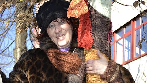 Agnes Maria Forsthofer von Linkshänder e.V. initiierte "Buntergiesing" und dekoriert Baumschals am Hans-Mielich-Platz.