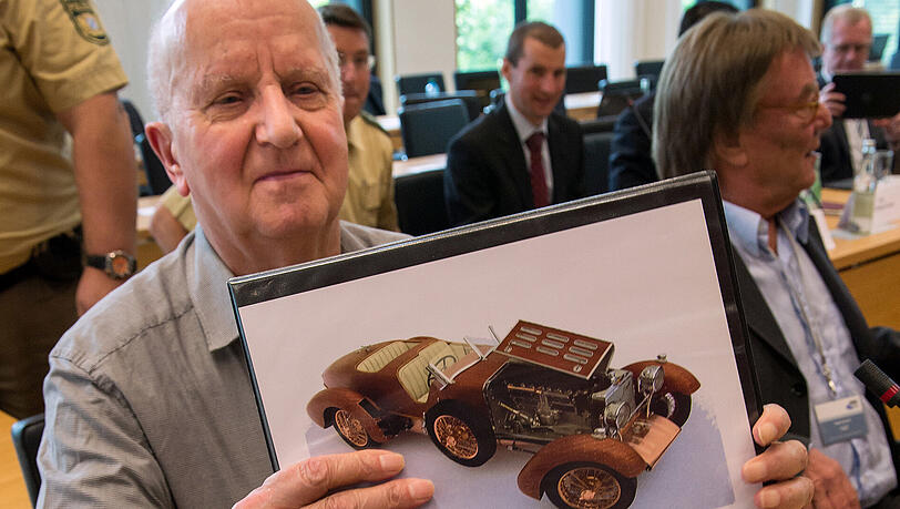 Mörder Roland S. zeigt Fotos der Automodelle, die er für die Haderthauers gebaut hat.