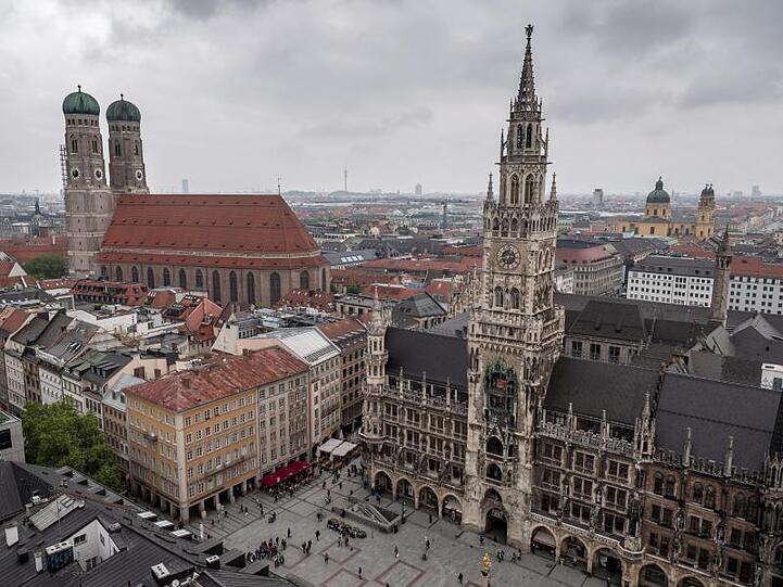 Dunkle Wolken ziehen über das Neue Rathaus und die Frauenkirche. Foto: Sina Schuldt/dpa