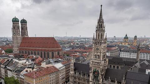 Dunkle Wolken ziehen über das Neue Rathaus und die Frauenkirche. Foto: Sina Schuldt/dpa