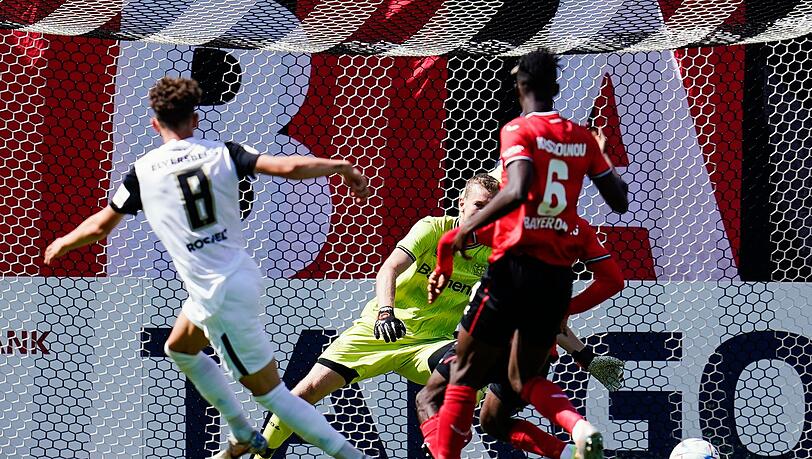 Elversbergs Jannick Rochelt (l) trifft an Leverkusens Torwart Lukas Hradecky vorbei zum 1:0.
