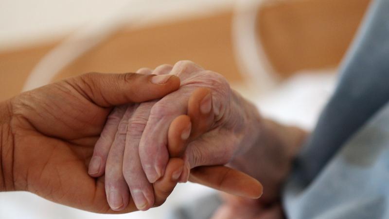 Eine Pflegerin hält im Altenheim die Hand einer Bewohnerin. Eine Pflegerin hält im Altenheim die Hand einer Bewohnerin.