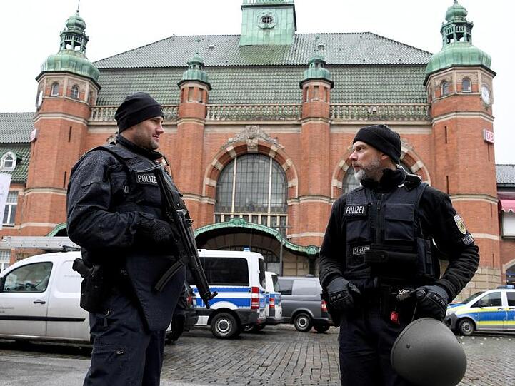 Polizeibeamte stehen vor dem Lübecker Hauptbahnhof. Der Bahnhof wurde nach einer Bombendrohung evakuiert und der Zugverkehr eingestellt.