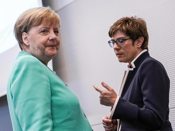Angela Merkel und Annegret Kramp-Karrenbauer sprechen vor einer Fraktionssitzung.