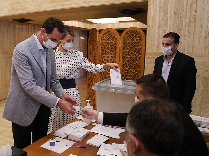 Baschar al-Assad, Präsident von Syrien, und seine Ehefrau Asma al-Assad, geben ihre Stimmzettel für die Parlamentswahlen in einem Wahllokal ab.