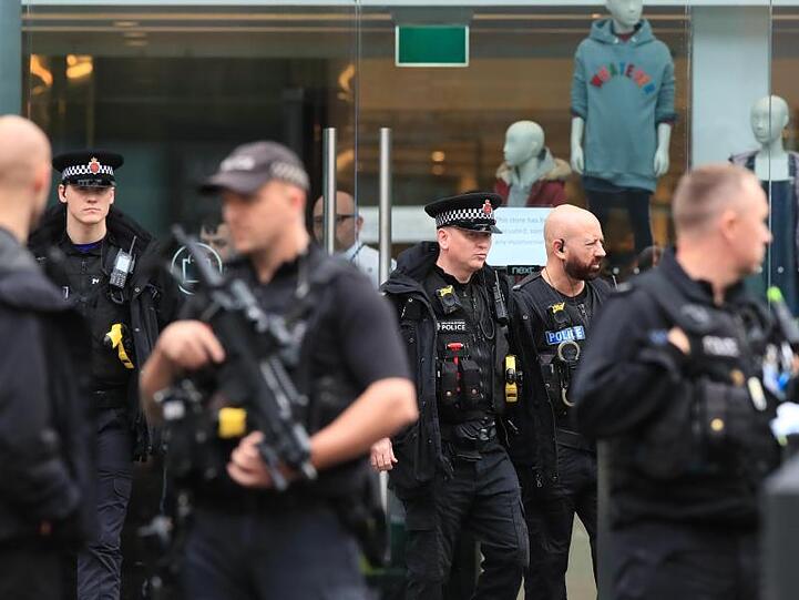 Vor dem Einkaufzentrum in Manchester sind Polizisten postiert.