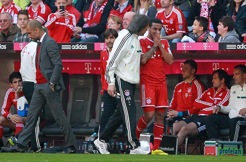 Doktor Hans-Wilhelm Müller-Wohlfahrt kümmert sich um Thiago, Trainer Pep Guardiola (l.) wendet sich ab.