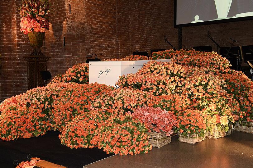 Der Sarg von Gerd Käfer liegt in einem orangefarbenen Blumenmeer
