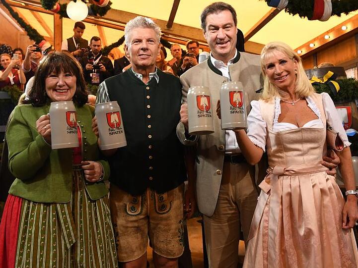 Dieter Reiter (2.v.l), seine Frau Petra (l), Markus Söder und seine Frau Karin Baumüller-Söder halten Masskrüge. Foto: Sven Hoppe/Archiv