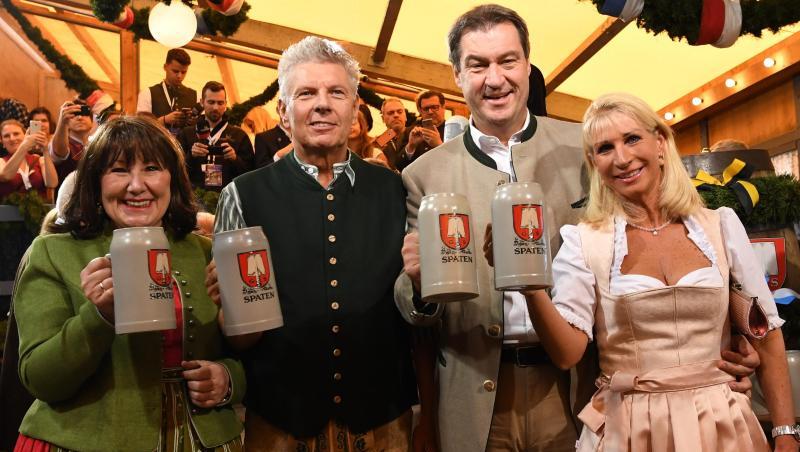 Dieter Reiter (2.v.l), seine Frau Petra (l), Markus Söder und seine Frau Karin Baumüller-Söder halten Masskrüge. Foto: Sven Hoppe/Archiv Dieter Reiter (2.v.l), seine Frau Petra (l), Markus Söder und seine Frau Karin Baumüller-Söder halten Masskrüge. Foto: Sven Hoppe/Archiv
