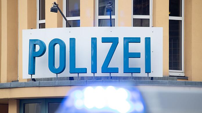 Ein Einsatzwagen der Polizei steht vor einer Dienststelle.