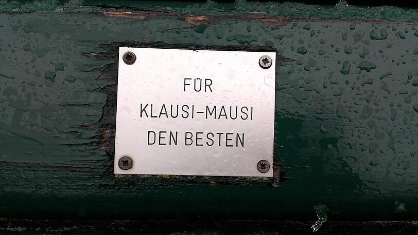Im Englischen Garten und Nymphenburger Schlosspark haben Münchner tausende Plaketten mit Widmungen auf Parkbänken angebracht.