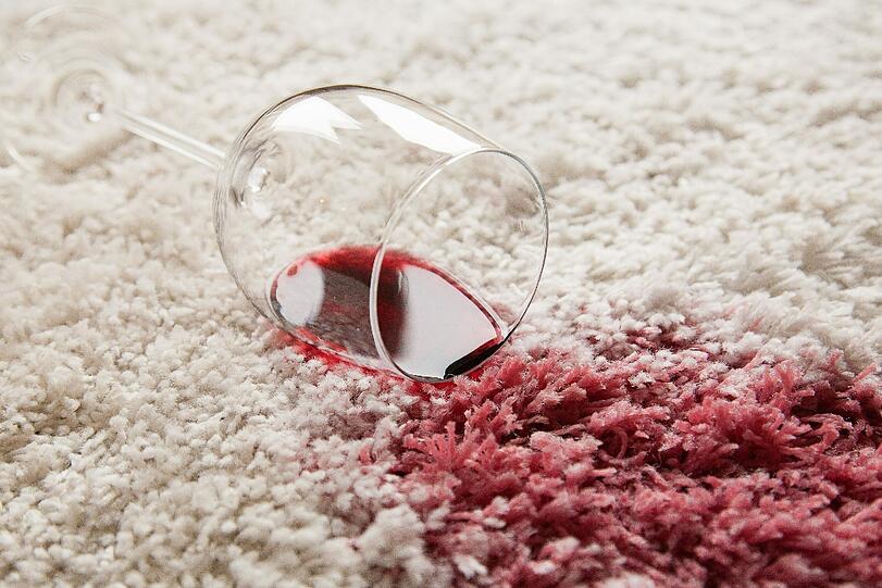 Dumm gelaufen: Das Glas fiel runter, Rotwein runiert den Teppich.