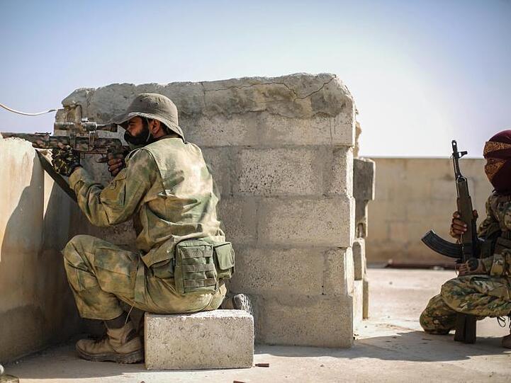 Ein Scharfschütze der mit der Türkei verbündeten Syrischen Nationalarmee zielt mit einer Waffe von einem Dach in Tall Abjad.