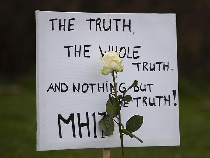 Ein Schild fordert von dem Prozess die Wahrheit über den Absturz ein.