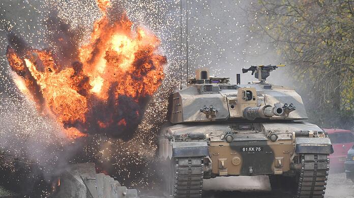 Eine Explosion ereignet sich in der Nähe eines Kampfpanzers vom Typ Challenger 2.