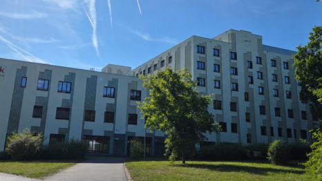 Der Haupteingang &uuml;ber den Sanatoriumsplatz an der Trambahnhaltestelle. Wegen des Klinik-Umzugs kommt es zu wichtigen &Auml;nderungen f&uuml;r Patientinnen und Patienten. (Transparenzhinweis: Auf dem Foto wurde mit KI ein Bauzaun entfernt.)