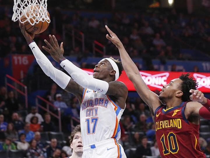 Dennis Schröder (l) von Oklahoma City Thunder setzt sich am Korb gegen Darius Garland von den Cleveland Cavaliers durch.