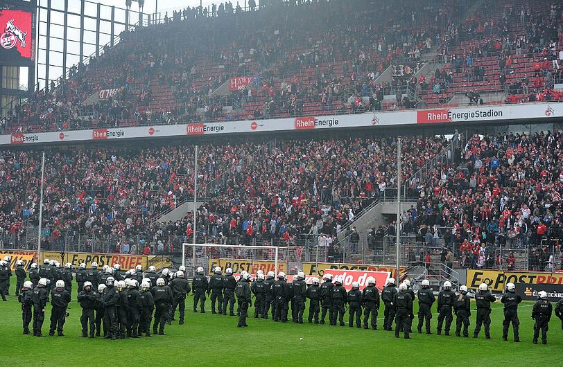 05.05.2012 Mit dem Schlusspfiff stürmen Hooligans des 1. FC Köln nach der 1:4-Niederlage gegen Bayern München den Platz und können nur von einem massiven Polizeiaufgebot in Schach gehalten werden. Zuvor waren bereits auf der Kölner Fantribüne Rauchbomben und Bengalische Feuer gezündet worden.