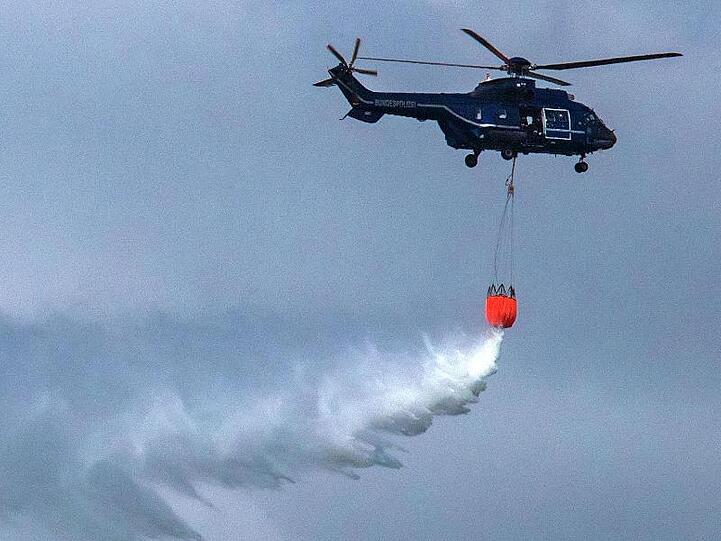 Wasserwerfer: Ein Hubschrauber der Bundespolizei im Einsatz gegen den Waldbrand bei Lübtheen.