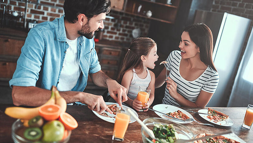Eine junge Familie mit einer selbst zubereiteten Pizza. Eine junge Familie mit einer selbst zubereiteten Pizza.