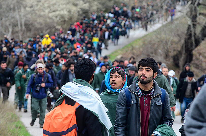 Hunderte Flüchtlinge aus dem Lager in Idomeni durchqueren einen reißenden Fluss auf griechischer Seite, um illegal nach Mazedonien zu gelangen.